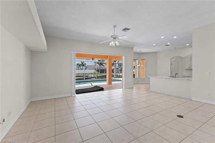 Unfurnished living room featuring ceiling fan and light tile patterned flooring