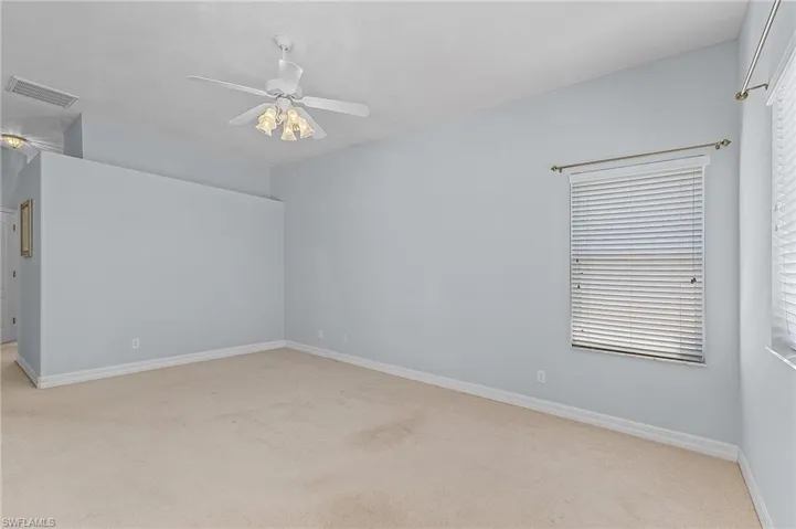 Carpeted spare room featuring ceiling fan