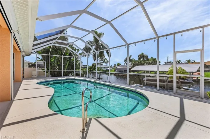 View of swimming pool featuring a patio area, a lanai, and a water view