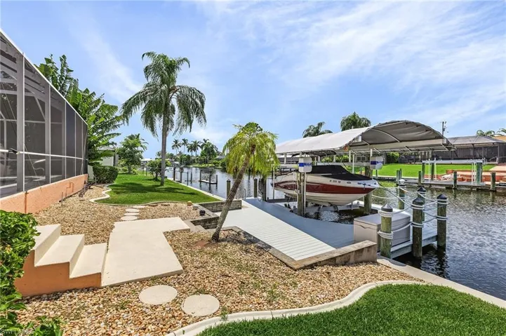 View of dock with a lanai and a water view