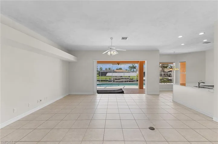 Tiled empty room featuring ceiling fan and sink