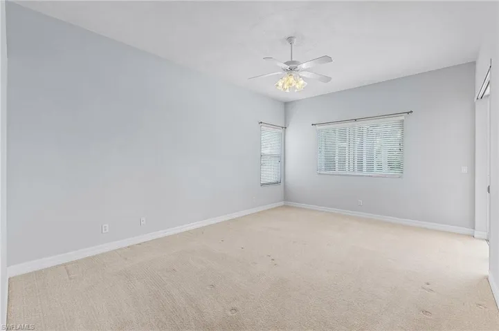 Unfurnished room with ceiling fan and light colored carpet