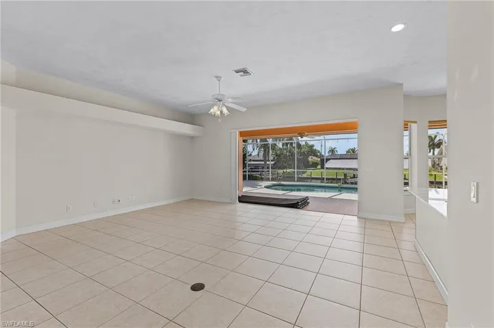 Empty room featuring ceiling fan, a healthy amount of sunlight, and light tile patterned floors