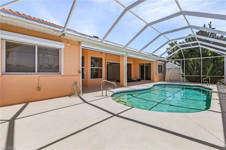 View of swimming pool featuring a patio area and a lanai