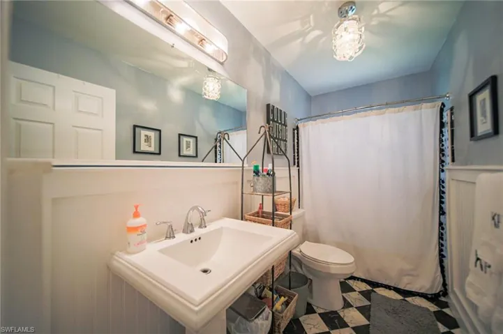 Bathroom featuring a pedestal sink, chrome-finish faucet, and a large wall-mounted mirror