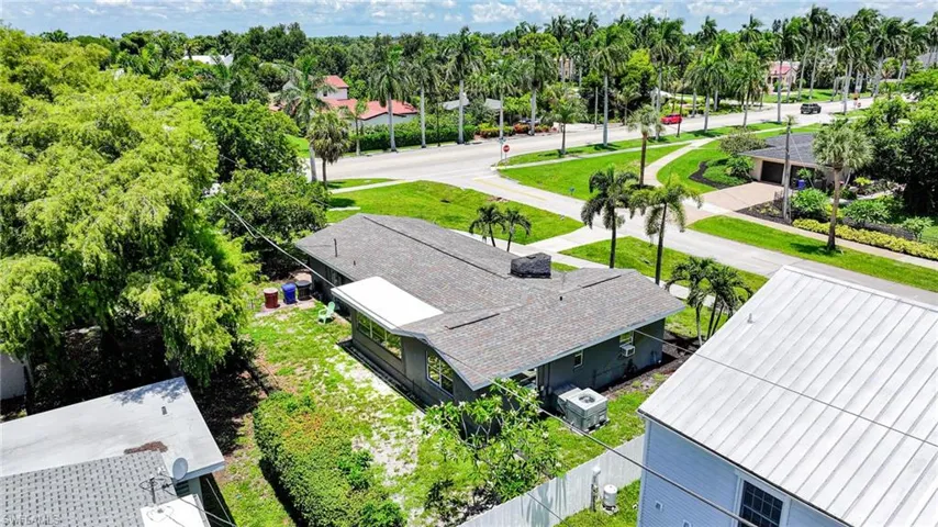 Single-story residence with a gray shingle roof and light gray siding, situated on a green lot