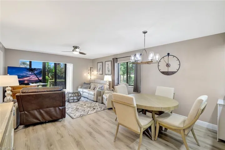 Dining space featuring plenty of natural light, light wood-type flooring, and ceiling fan with notable chandelier