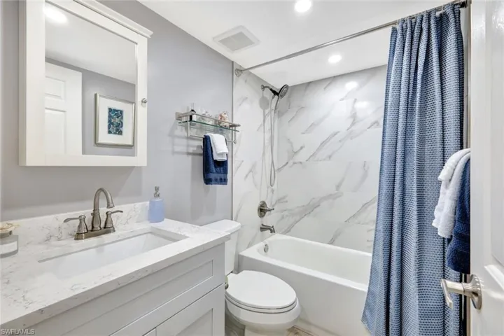Full bathroom featuring shower / bath combination with curtain, vanity, and toilet