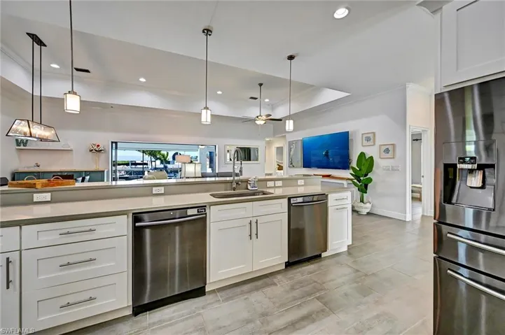 Large island with double dishwashers, view to living room, lanai, and a relaxing pool/spa.