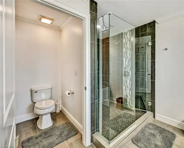 Primary Bathroom with a full tile shower, tile floor, and a bench seat.