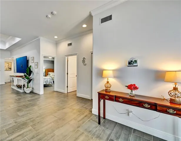 Entryway featuring crown molding, tile floors, and recessed lighting.