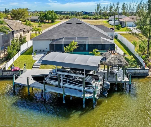 Dock area featuring a lanai, boat lift, and a canal view