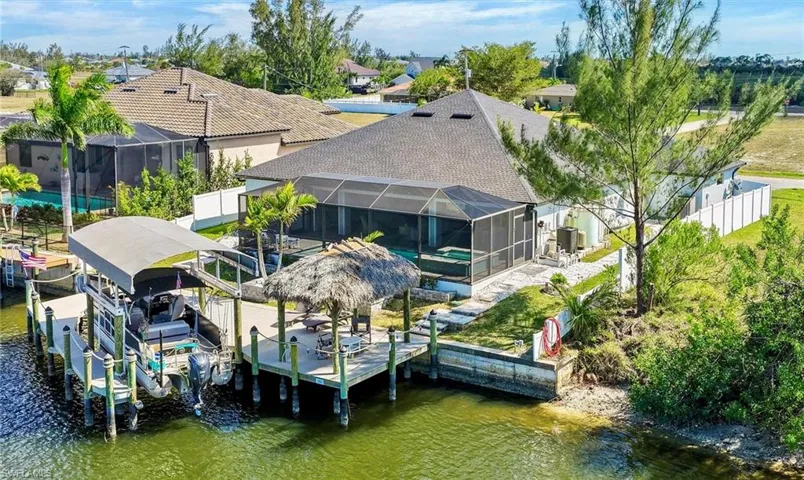 Dock area with a lanai, 14k boat lift, sun deck, and canal view