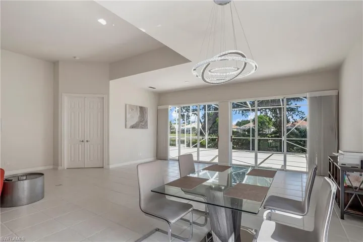 Dining room featuring light tile patterned floors, baseboards, and a chandelier