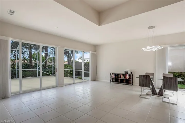 Living area with tile patterned floors, baseboards, a chandelier, and visible vents