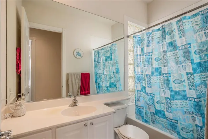 Full bathroom featuring toilet, vanity, and shower / bath combo with shower curtain