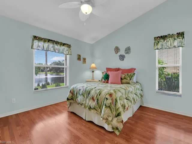 Bedroom featuring wood finished floors, a water view, and ceiling fan