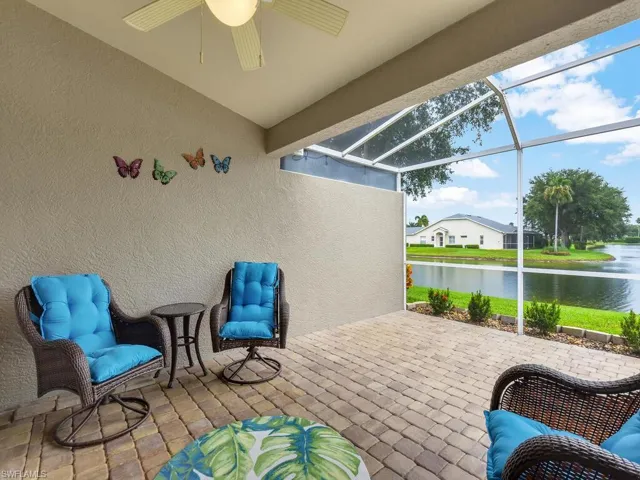 View of patio with a ceiling fan, a water view, and a lanai