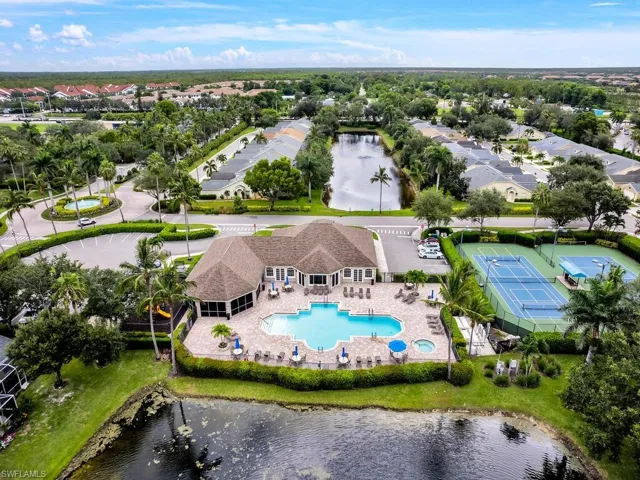 Aerial view of residential area with a nearby body of water and a pool