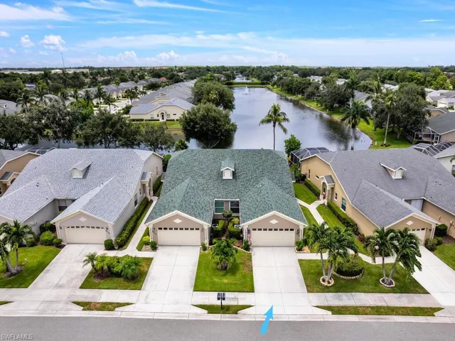 Aerial perspective of suburban area featuring a nearby body of water