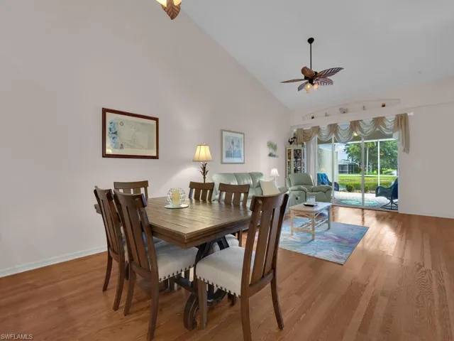 Dining room featuring a ceiling fan, high vaulted ceiling, and light wood finished floors