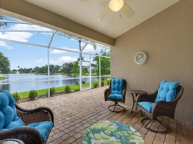 Sunroom / solarium featuring ceiling fan, a water view, and vaulted ceiling