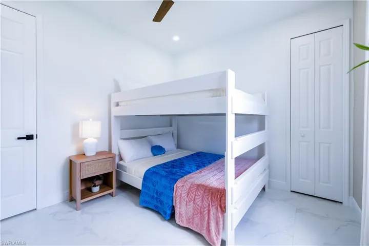 Bedroom featuring light marble finish floors, ceiling fan, and recessed lighting