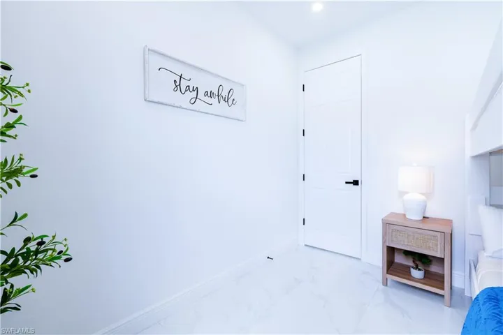 Bedroom with baseboards and marble look tile flooring