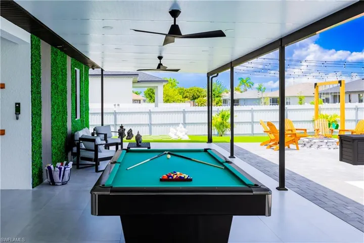 Game room with a wall of windows, pool table, and a ceiling fan