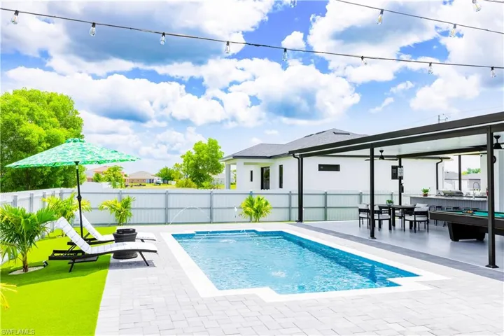 View of pool featuring a fenced backyard, a patio area, a ceiling fan, and outdoor dining space