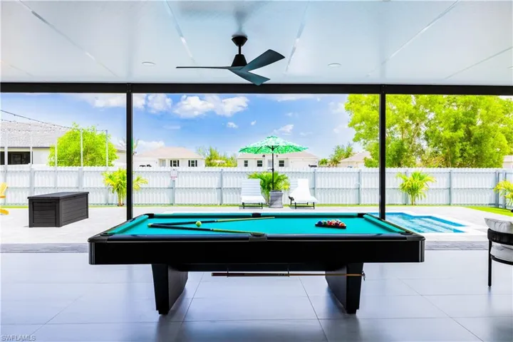 Game room with a wall of windows, billiards, tile patterned flooring, and ceiling fan