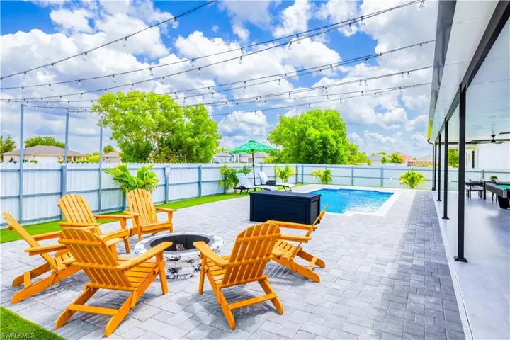 View of swimming pool featuring a fire pit, a patio area, a fenced backyard, and a ceiling fan