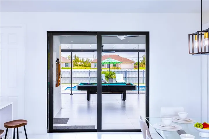 Doorway with tile patterned floors, plenty of natural light, and pool table
