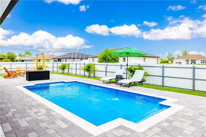 View of pool featuring a residential view, a fenced backyard, and a patio