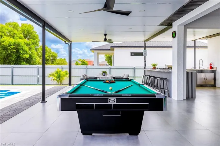 Recreation room featuring a wall of windows, pool table, and a ceiling fan