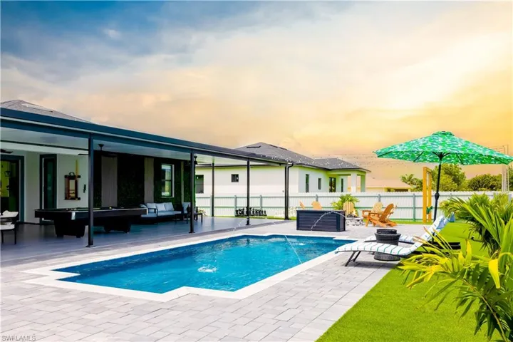 View of pool with outdoor lounge area, a patio area, a fenced backyard, and a ceiling fan