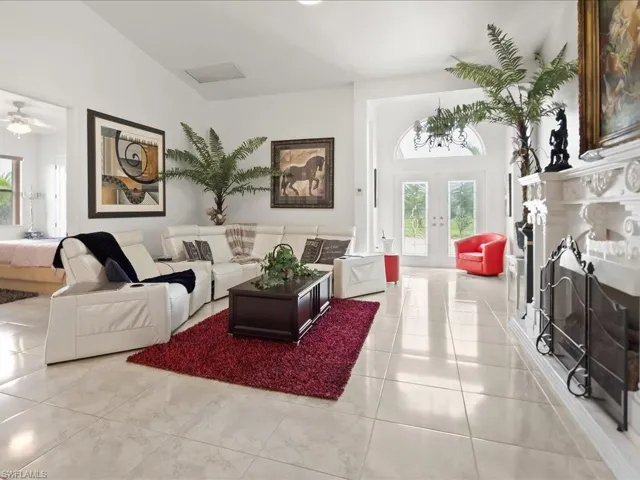 Living room featuring french doors, a fireplace, plenty of natural light, and tile patterned floors