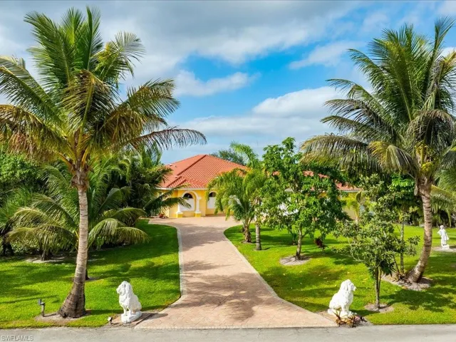 View of front of house featuring decorative driveway, a front lawn, and a tiled roof