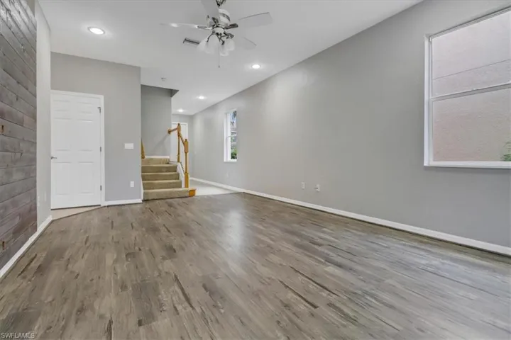Unfurnished living room featuring hardwood / wood-style flooring and ceiling fan