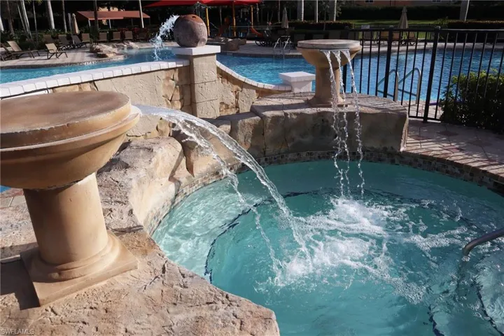 View of pool featuring pool water feature and a jacuzzi
