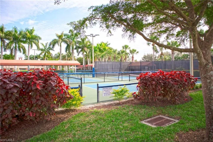 View of tennis court featuring a yard