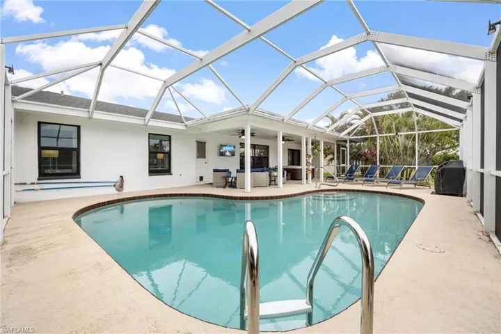 View of swimming pool with a lanai and a patio