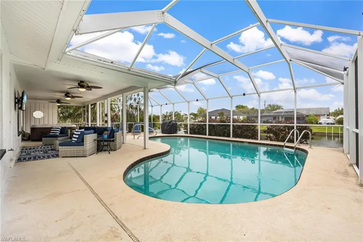 View of pool with ceiling fan, a lanai, a patio, and an outdoor hangout area