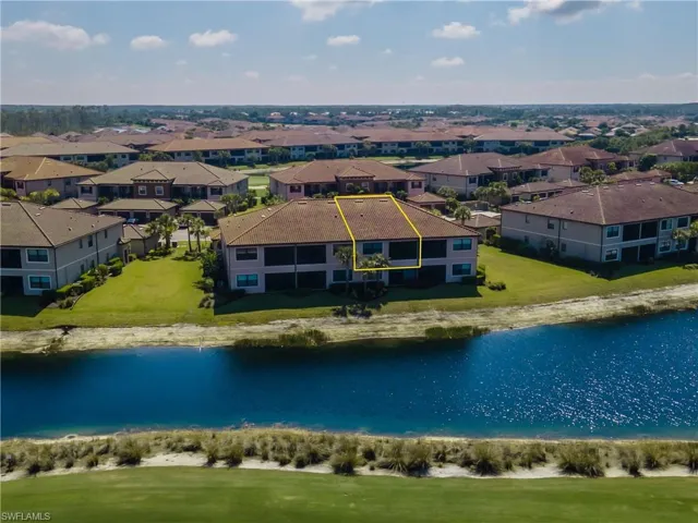 Aerial perspective of suburban area with a nearby body of water and property boundaries highlighted