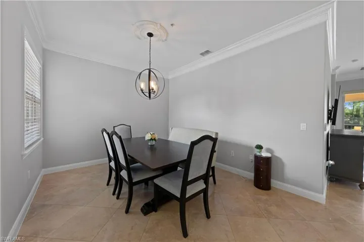 Dining area featuring crown molding and modern chandelier