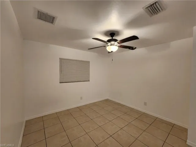 Unfurnished room with ceiling fan and light tile patterned floors