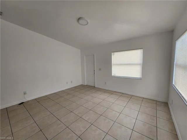 Spare room with baseboards and light tile patterned flooring