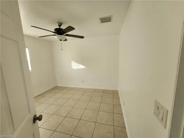 Unfurnished room featuring light tile patterned floors and a ceiling fan