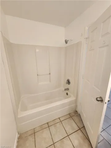 Bathroom featuring tile patterned floors and bathing tub / shower combination