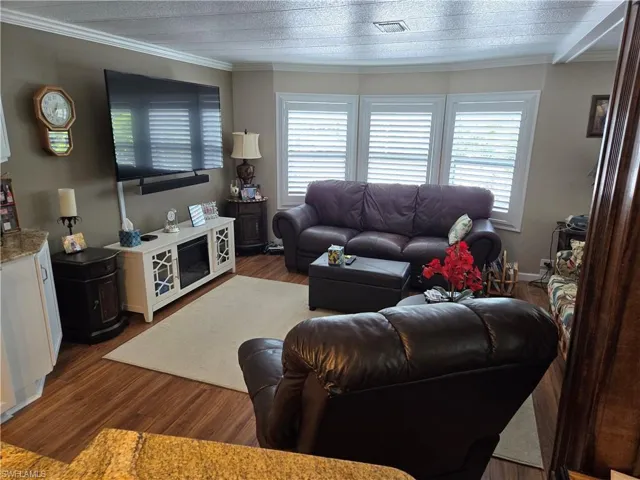 Living room featuring ornamental molding and hardwood / wood-style floors